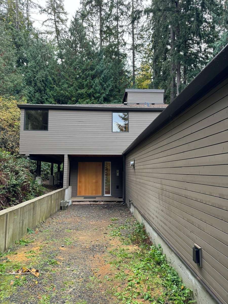 Horizontal lap siding and a wood entry door on a wooded Eastside home